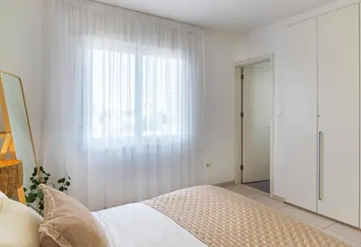 a white bedroom with a bed and a window at Sirena Solis Villa - Elegant 5-bedroom Sea View Retreat near Sirena Bay in Protaras