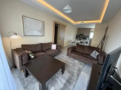 a living room with two couches and a table at 2 BR apartment in the Limassol with sea view in Limassol