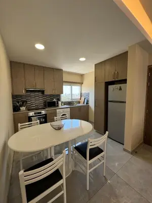 a kitchen with a table and chairs and a refrigerator at 2 BR apartment in the Limassol with sea view in Limassol