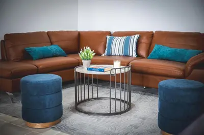 a living room with a couch and two blue stools at Althaea Mare in Lofou