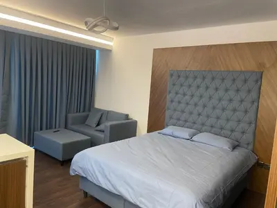 a hotel room with a bed and a chair at Grand Sapphire Resort in Aglantzia