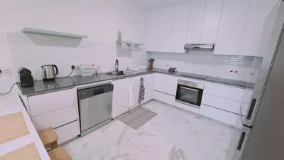 a white kitchen with a sink and a dishwasher at STAY The Getaway Apartment in Pyla