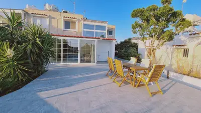 a patio with a table and chairs in front of a house at STAY The Getaway Apartment in Pyla
