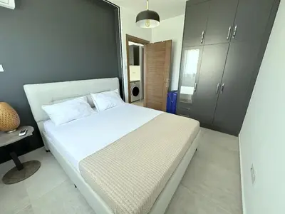 a bedroom with a white bed and a desk at Cheap Holiday Opportunity in North Cyprus in Larnaka