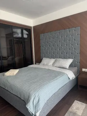 a bedroom with a large bed with a gray headboard at Grand Saphire Resort Apartment-I in İskele