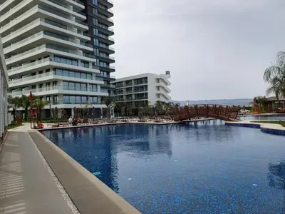 a large swimming pool next to a tall building at Grand Saphire Resort Apartment-I in İskele