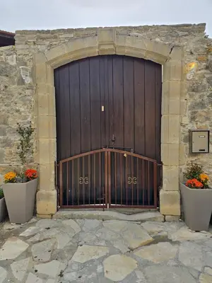 a large wooden garage door with two pots of flowers at Xenonas Hiliostrofi in Anoyira