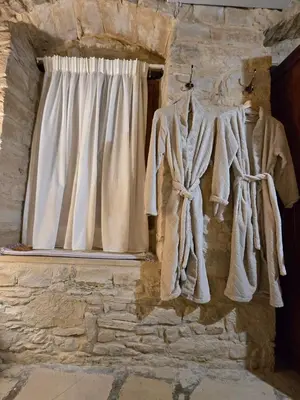 a group of clothes hanging on a wall next to a window at Xenonas Hiliostrofi in Anoyira