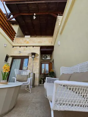 a patio with white chairs and a bath tub at Xenonas Hiliostrofi in Anoyira
