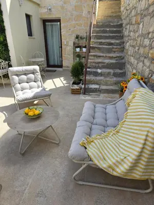 a patio with a couch and a table and stairs at Xenonas Hiliostrofi in Anoyira