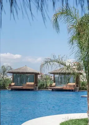 a view of a lake with two pavilions at Grand Sapphire Resort in Aglantzia