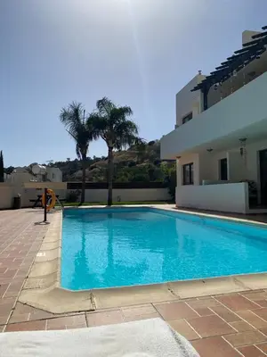 a large blue swimming pool next to a house at 2 Bed Apartment Pool and Sea Views in Oroklini in Voroklini