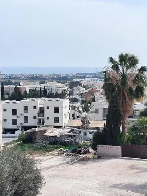 a city with white buildings and a palm tree at 2 Bed Apartment Pool and Sea Views in Oroklini in Voroklini