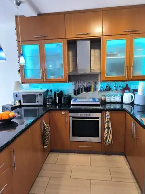 a kitchen with wooden cabinets and a stove top oven at 2 Bed Apartment Pool and Sea Views in Oroklini in Voroklini