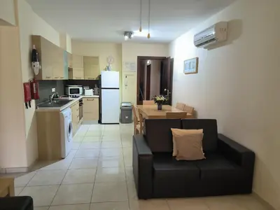 a living room with a black couch in a kitchen at 2 Bed Apartment in Kiti with Communal Pool in Kiti