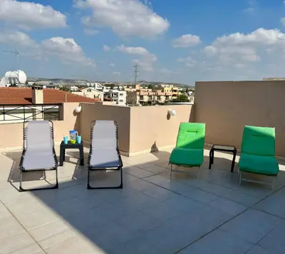 three chairs and a table on a roof at 2 Bedroom Penthouse Apartment in Oroklini with Communal Pool in Voroklini