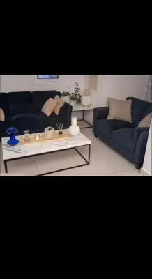 a living room with two blue couches and a coffee table at MERAKI Villa in Paralimni