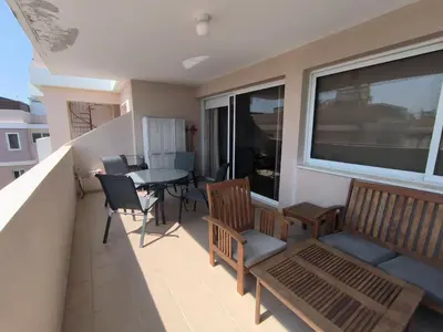 a balcony with a table and chairs and a dining room at Superior 1 bed apartment in Oroklini with Communal Pool in Voroklini