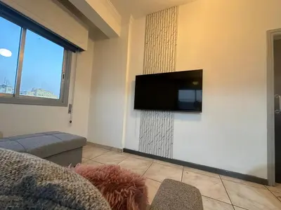 a living room with a flat screen tv on a wall at Adonis Holiday Apt - Nicosia in Nicosia