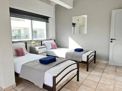 a room with two beds and a mirror at Adonis Holiday Apt - Nicosia in Nicosia