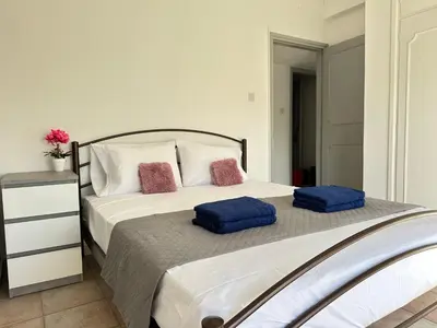 a bedroom with a bed with two blue pillows on it at Adonis Holiday Apt - Nicosia in Nicosia