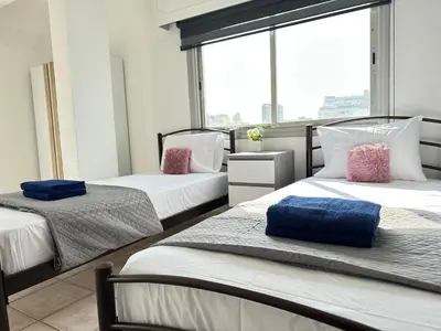 three beds in a room with a window at Adonis Holiday Apt - Nicosia in Nicosia