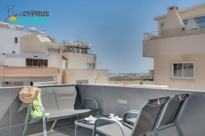 a balcony with a bench and chairs on a building at Makenzy Star 2bd duplex 300m from beach in Larnaka