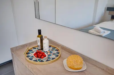 a tray with a bottle of wine and a plate of food at Makenzy Star 2bd duplex 300m from beach in Larnaka