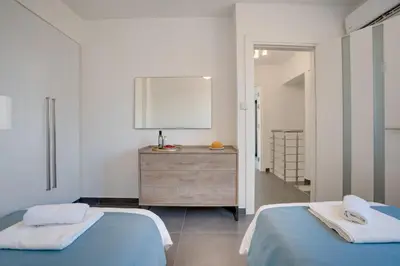 a bedroom with two beds and a dresser in it at Makenzy Star 2bd duplex 300m from beach in Larnaka
