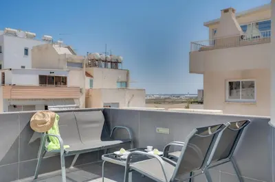 a balcony with chairs and a table on a building at Makenzy Star 2bd duplex 300m from beach in Larnaka