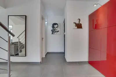 a hallway with red and white walls and a staircase at Makenzy Star 2bd duplex 300m from beach in Larnaka