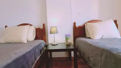 a bedroom with two beds and a table with a lamp at STAY Virtuoso Apartment in Nicosia