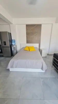 a bedroom with a white bed with yellow pillows at RIVERA Studios 1 in Limassol
