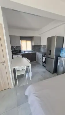 a kitchen with a white table and a refrigerator at RIVERA Studios 1 in Limassol