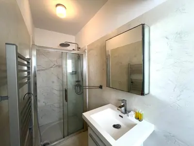 a bathroom with a sink and a shower and a mirror at The Comfort Stay in Nicosia Verenikis - Platform 357 in Nicosia