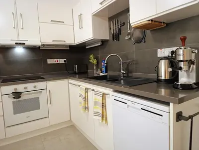 a kitchen with white cabinets and a sink at Family large apartment in Bahçeli in Aglantzia