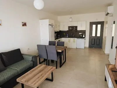 a living room with a couch and a table and a kitchen at Family large apartment in Bahçeli in Aglantzia