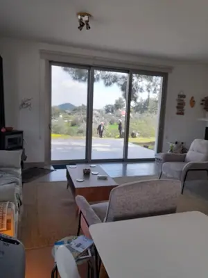 a living room with a large window and a table at Olive & Pinetree House in Lythrodontas