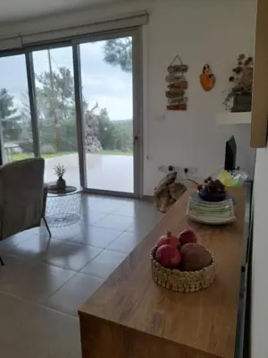 a kitchen with a table with a bowl of fruit on it at Olive & Pinetree House in Lythrodontas