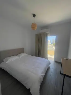 a bedroom with a large white bed and a window at Green Bay Cosy Escape in Protaras