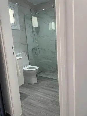 a bathroom with a toilet and a glass shower at Green Bay Cosy Escape in Protaras
