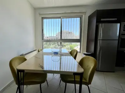 a kitchen with a table with chairs and a window at Cozy Stay Nicosia in Nicosia