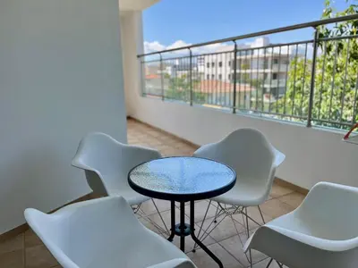a room with a table and chairs and a balcony at Cozy Stay Nicosia in Nicosia