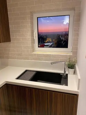 a kitchen with a sink with a tv above it at Limassol Marina Seaview Suite in Limassol
