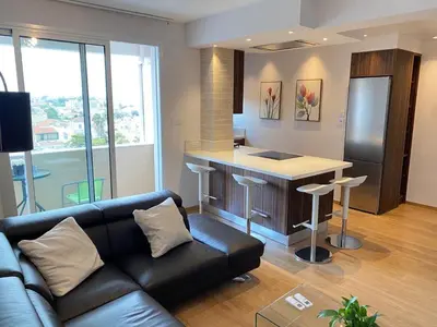 a living room with a couch and a kitchen at Limassol Marina Seaview Suite in Limassol