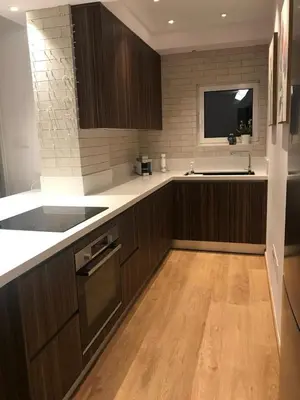 a kitchen with wooden cabinets and a sink and a counter at Limassol Marina Seaview Suite in Limassol
