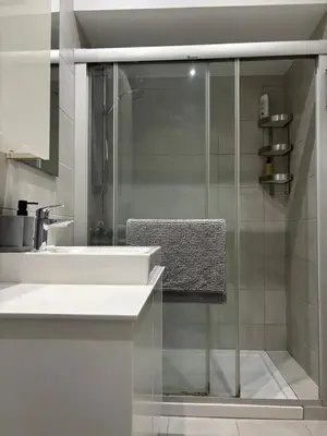 a bathroom with a sink and a glass shower at 3 Bedroom Oceanfront Oasis for Memorable Vacations in Voroklini