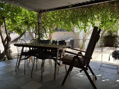 a wooden table and chairs on a patio at 3 Bedroom Oceanfront Oasis for Memorable Vacations in Voroklini