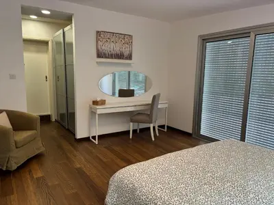 a bedroom with a bed and a desk and a mirror at 3 Bedroom Oceanfront Oasis for Memorable Vacations in Voroklini