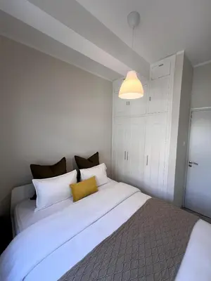 a bedroom with a large white bed with a yellow pillow at Casi-Homes in Larnaka